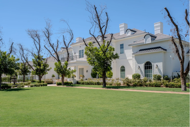 White luxury home with landscaped lawn at Ivy Lane
